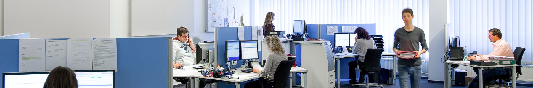 Büroraum mit Mitarbeitern am Computer