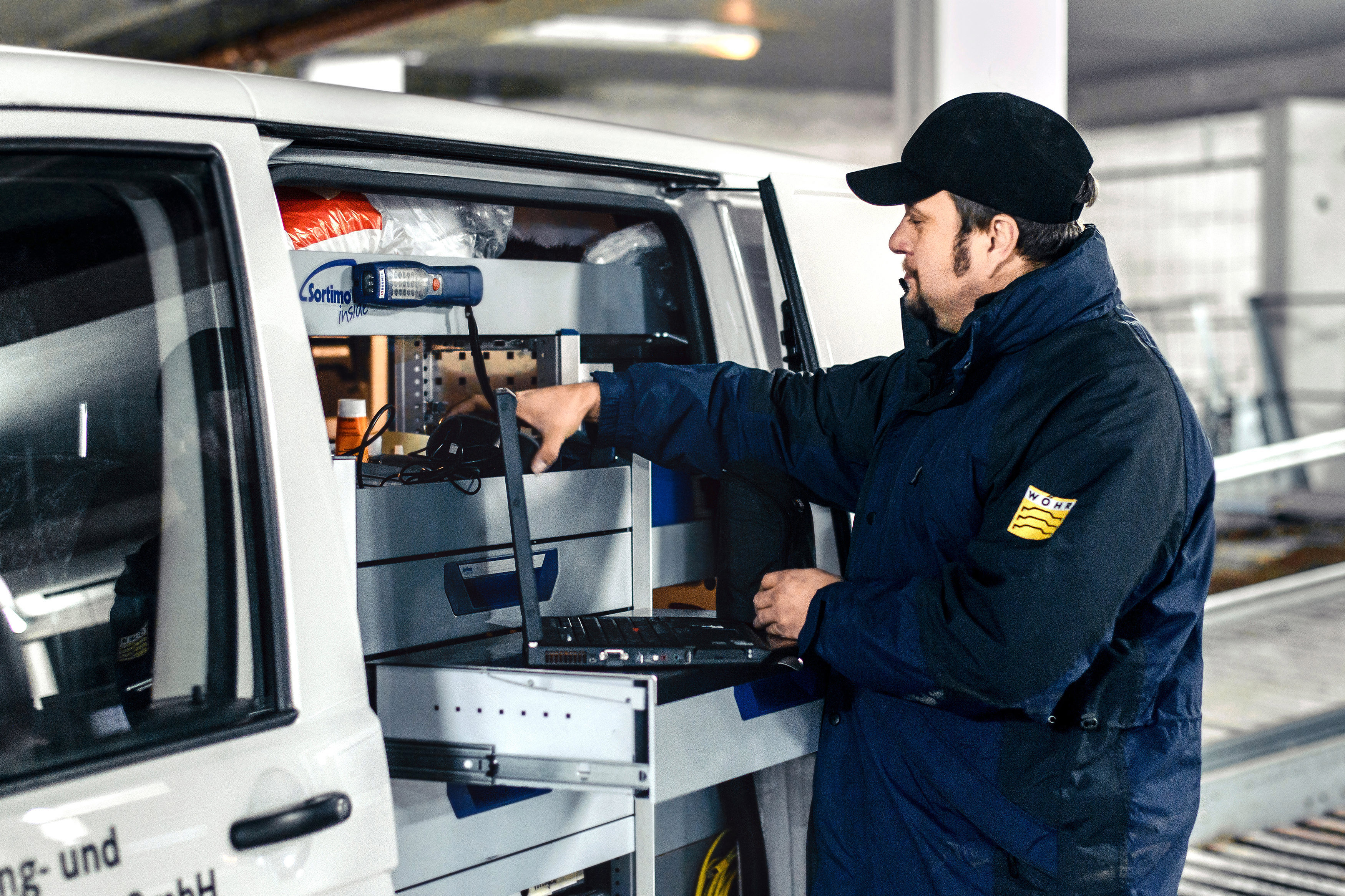Mann räumt Werkzeuge in sein Auto